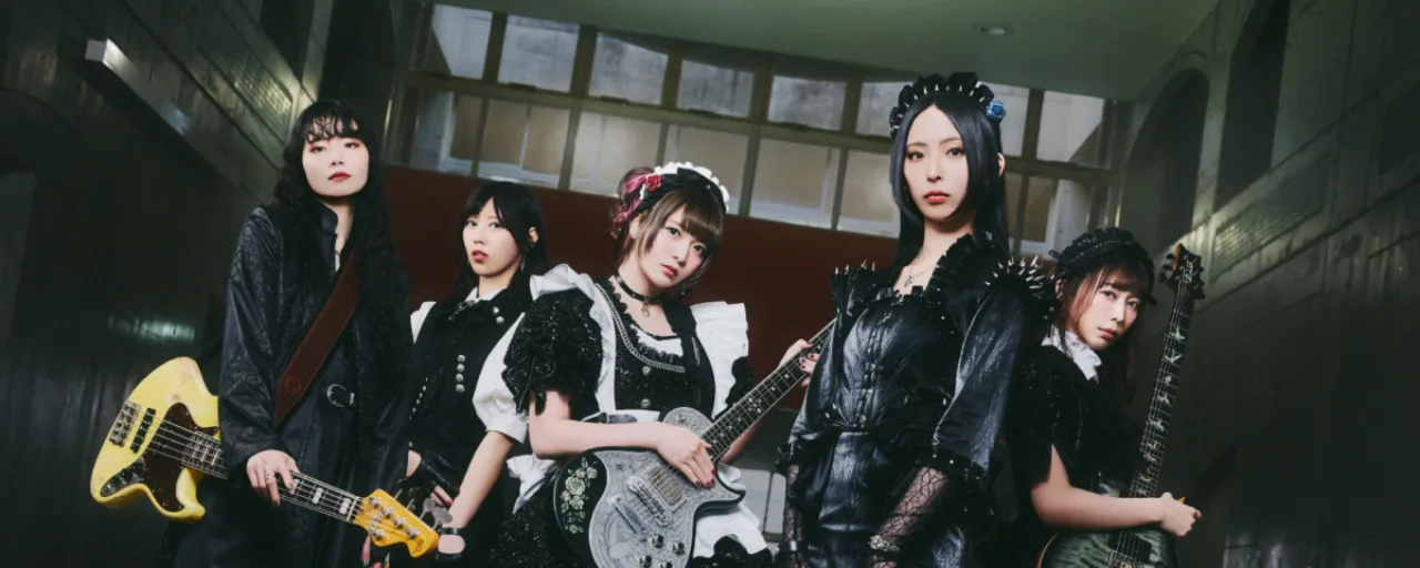 A banda BAND-MAID no palco do The Paramount, iluminada por luzes vermelhas, com guitarras e bateria em ação