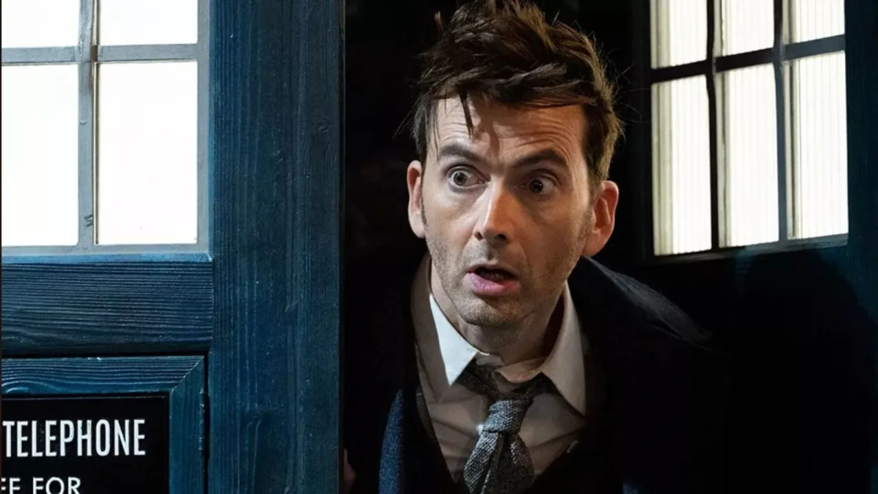 Tela da BBC exibindo o logo de Doctor Who cercado por luzes de Natal e um microfone de estúdio