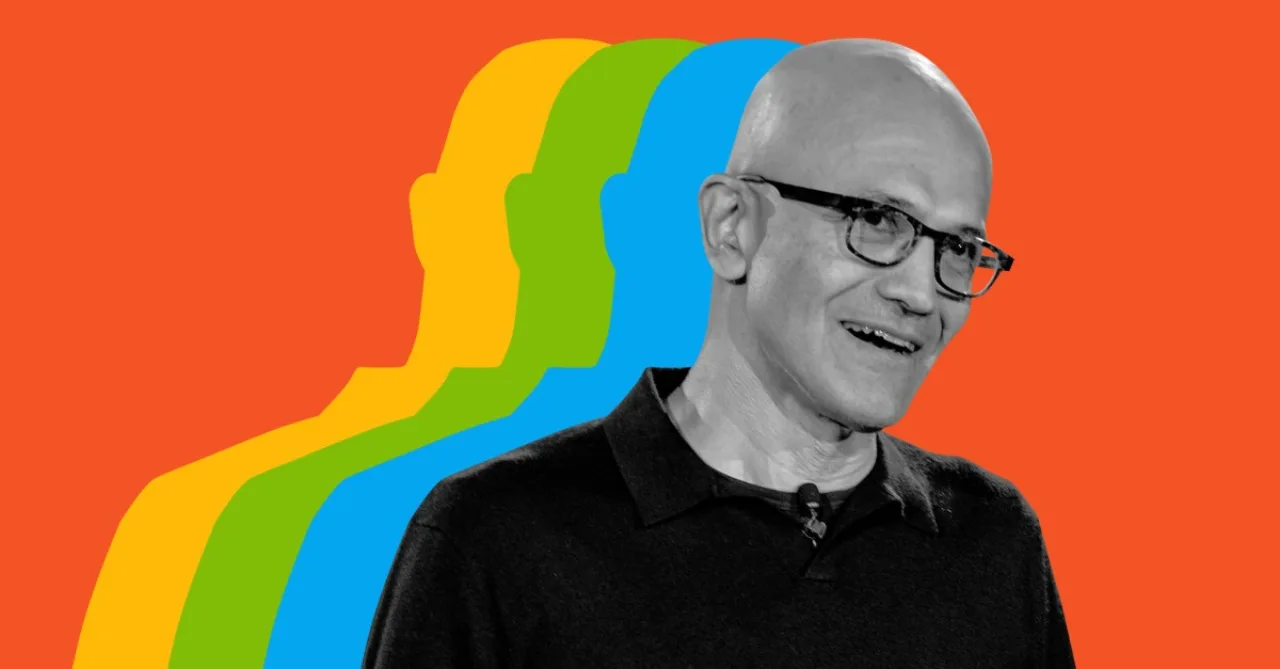 Satya Nadella em frente a telas com códigos e o logotipo da Microsoft, apontando para um ícone de IA
