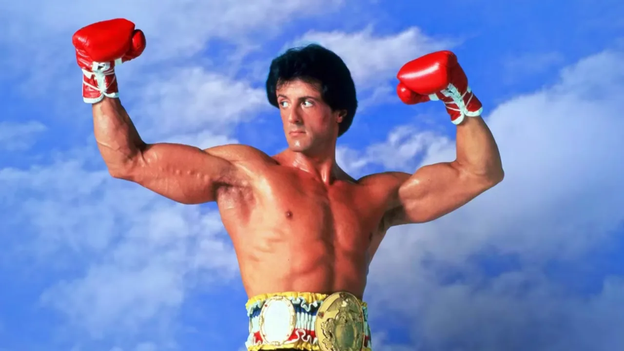 Botas Nike de boxe customizadas de Rocky III apoiadas sobre um saco de pancadas, com luvas e corda de pular ao fundo