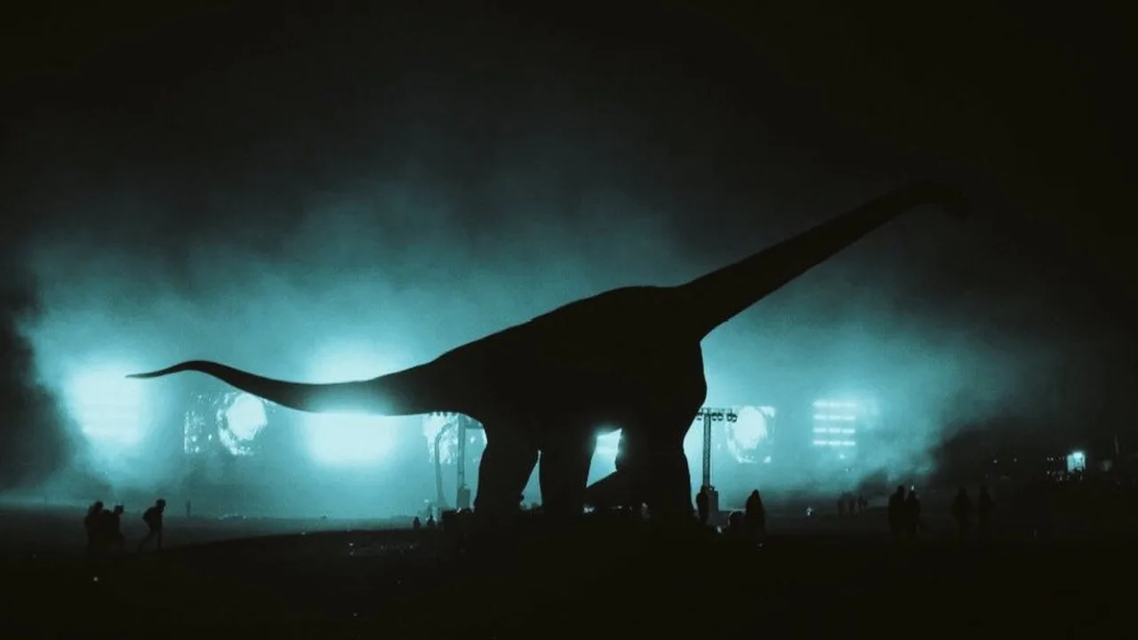 Jovem de camiseta vintage correndo na esteira, segurando pipoca enquanto projeta cena de dinossauro na tela