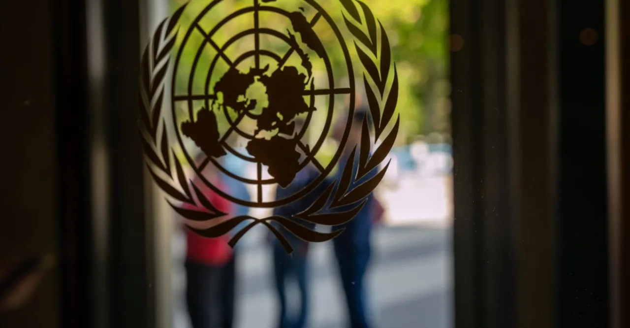 Logotipo da ONU ao fundo, robô de IA segurando um globo digital ao lado dos ícones da OpenAI e Hugging Face