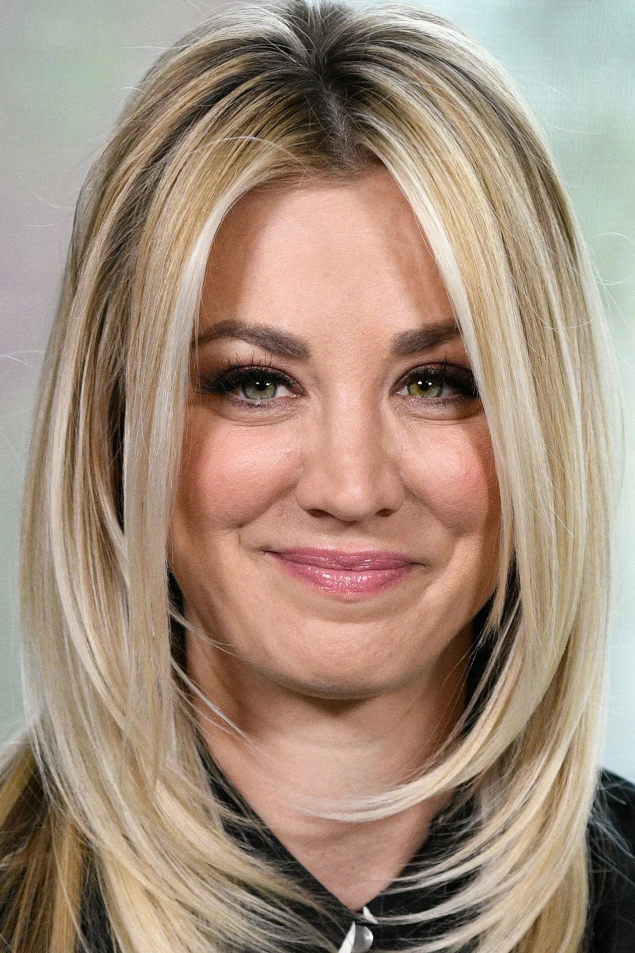 Kaley Cuoco de 9 anos usando roupa esportiva, segurando um haltere ao lado de Denzel Washington no set