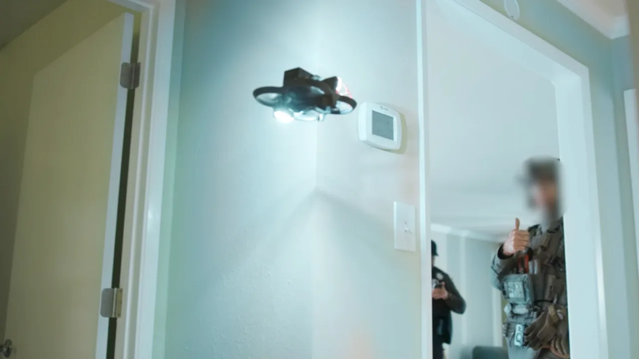 Policial em uniforme segurando drone quadricóptero enquanto um homem em roupa esportiva entrega uma faca