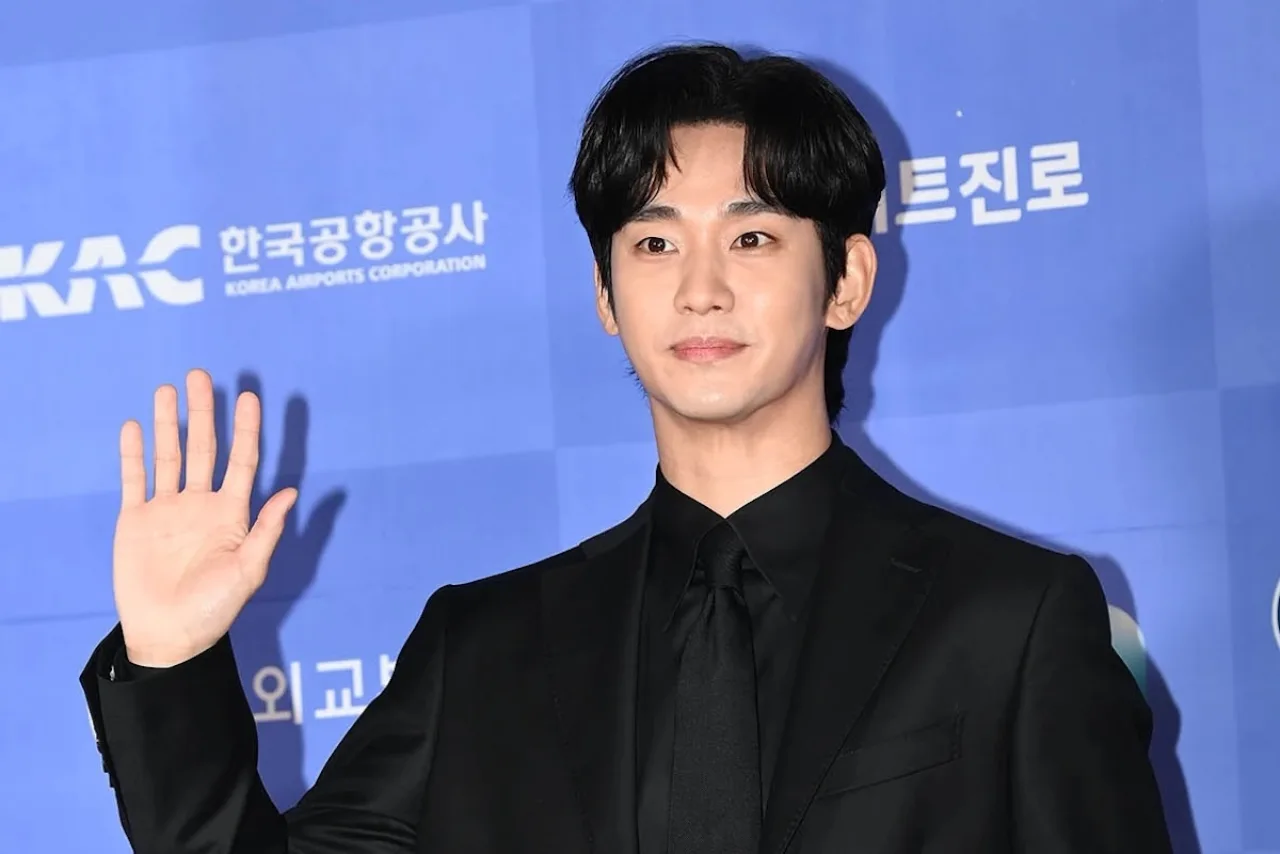 Kim Soo Hyun vestindo roupa esportiva, segurando garrafa de água e fazendo alongamento ao lado de halteres