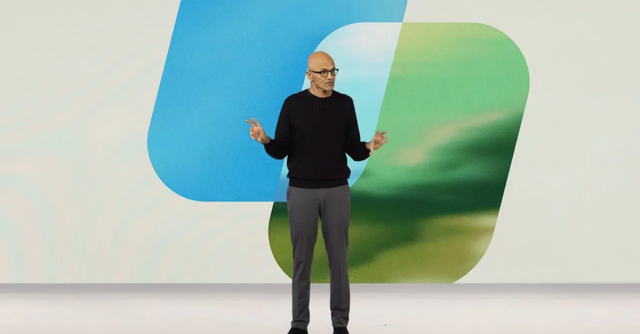 Satya Nadella no palco ao lado do logotipo do Microsoft Copilot, mostrando “sistema operacional” corporativo