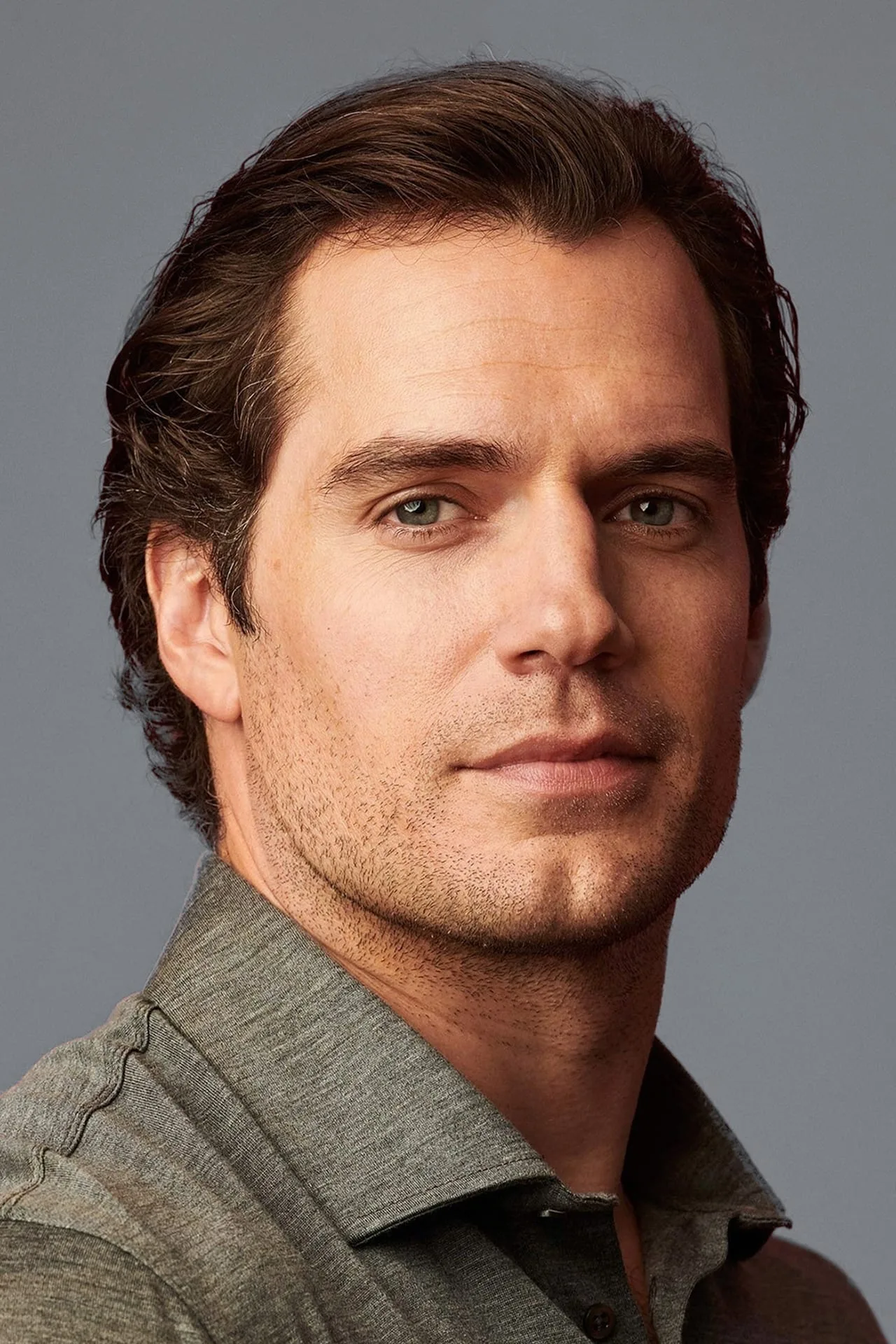 Henry Cavill treinando intensamente com halteres em uma academia moderna, exibindo foco e preparo físico impecável