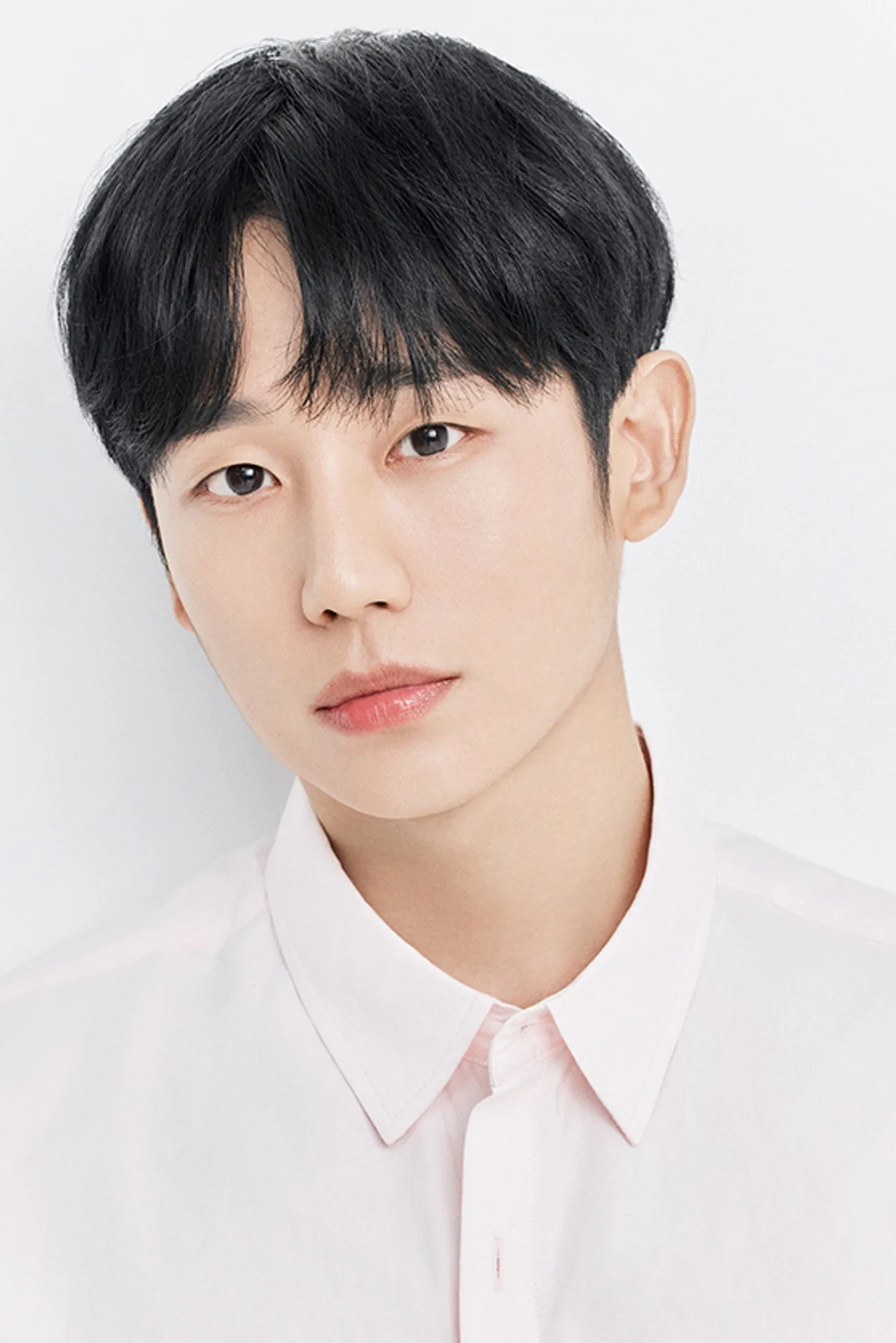 Jung Hae In treinando com kettlebell em academia minimalista, suando e vestindo roupa esportiva preta