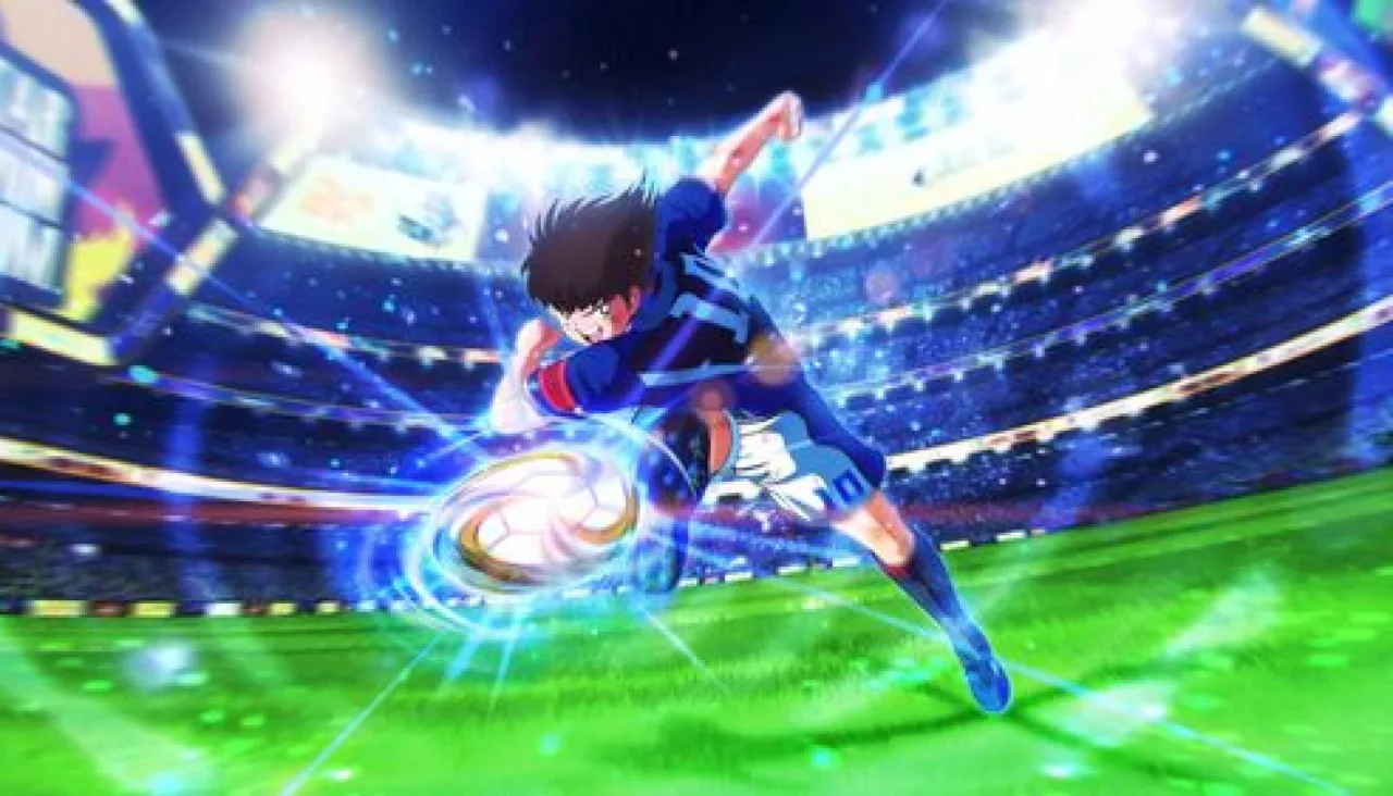 Atleta vestindo camiseta azul, segurando bola de futebol, ao lado de halteres e garrafa de água