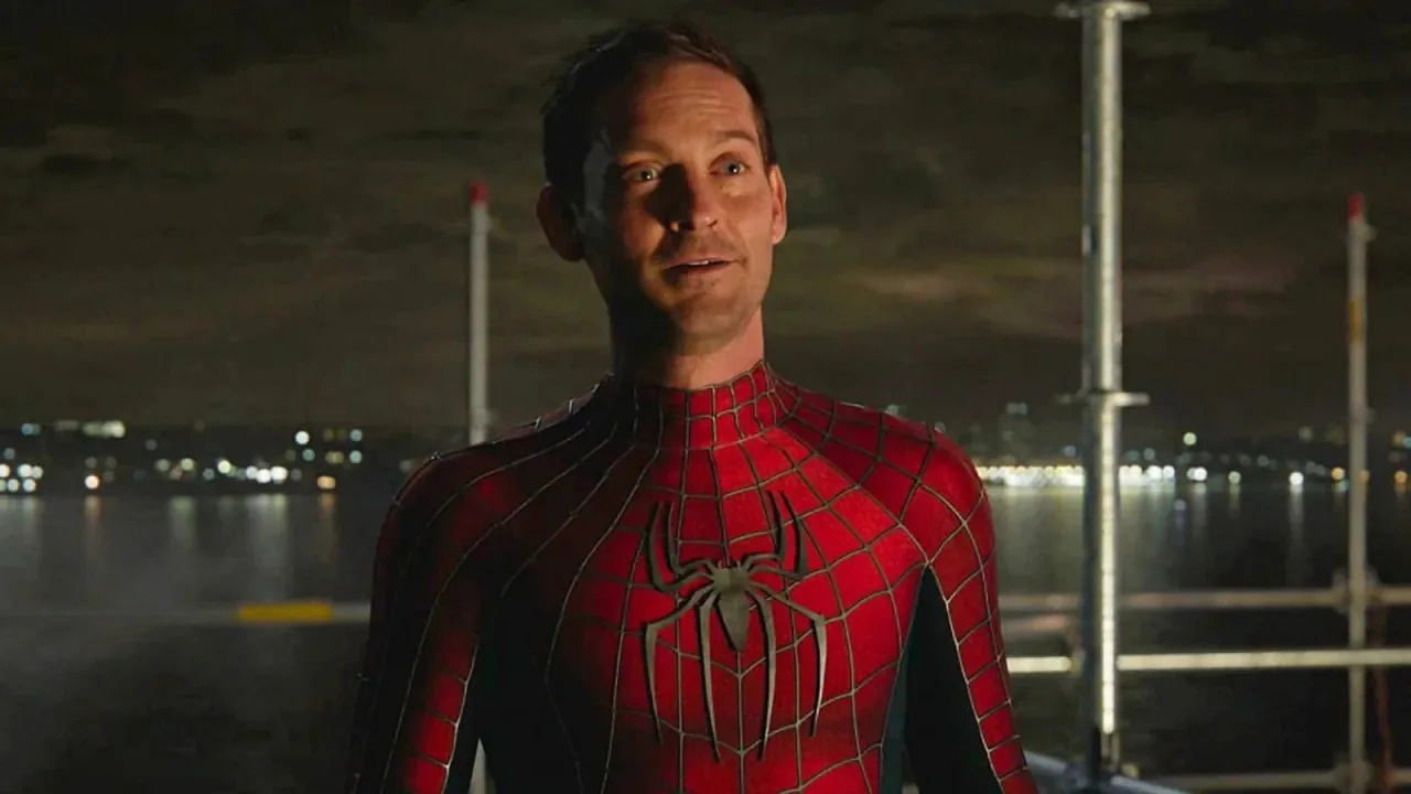 Homem em roupa esportiva faz flexão ao lado de pôster de Avengers com Tobey Maguire