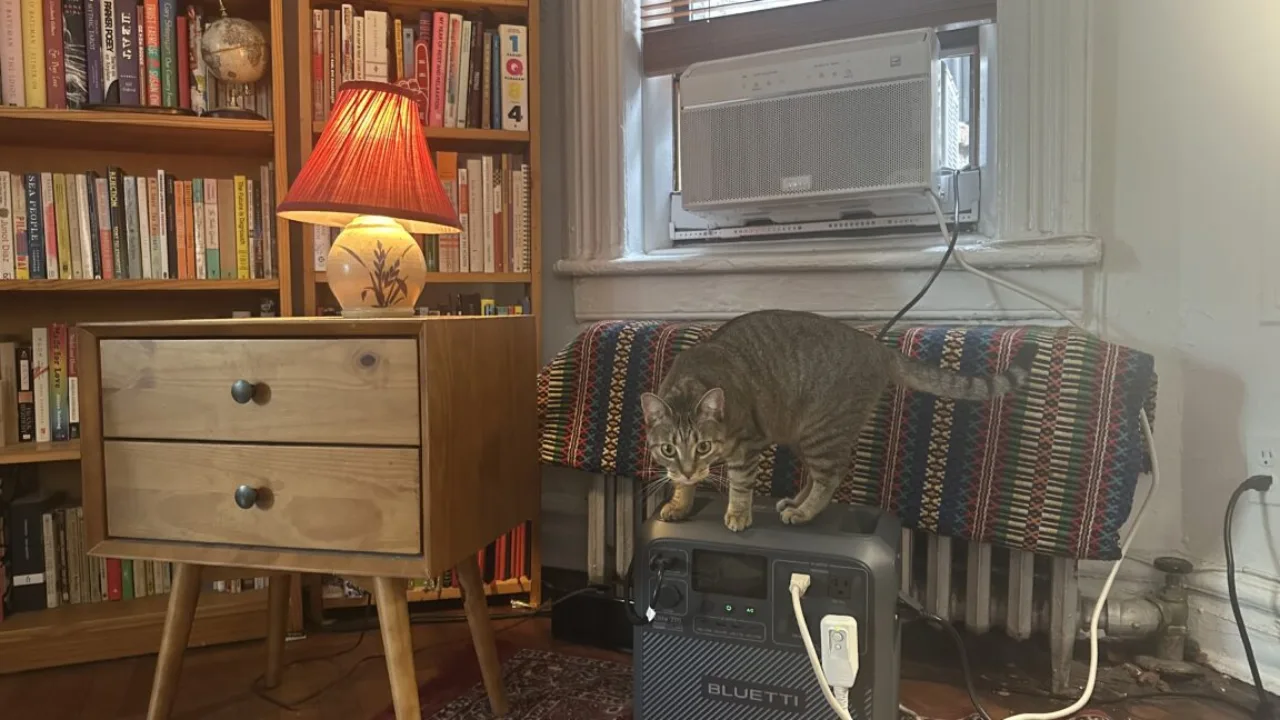 Logo da Every Electric e baterias ao lado de um ar‑condicionado em apartamento de Nova Iorque