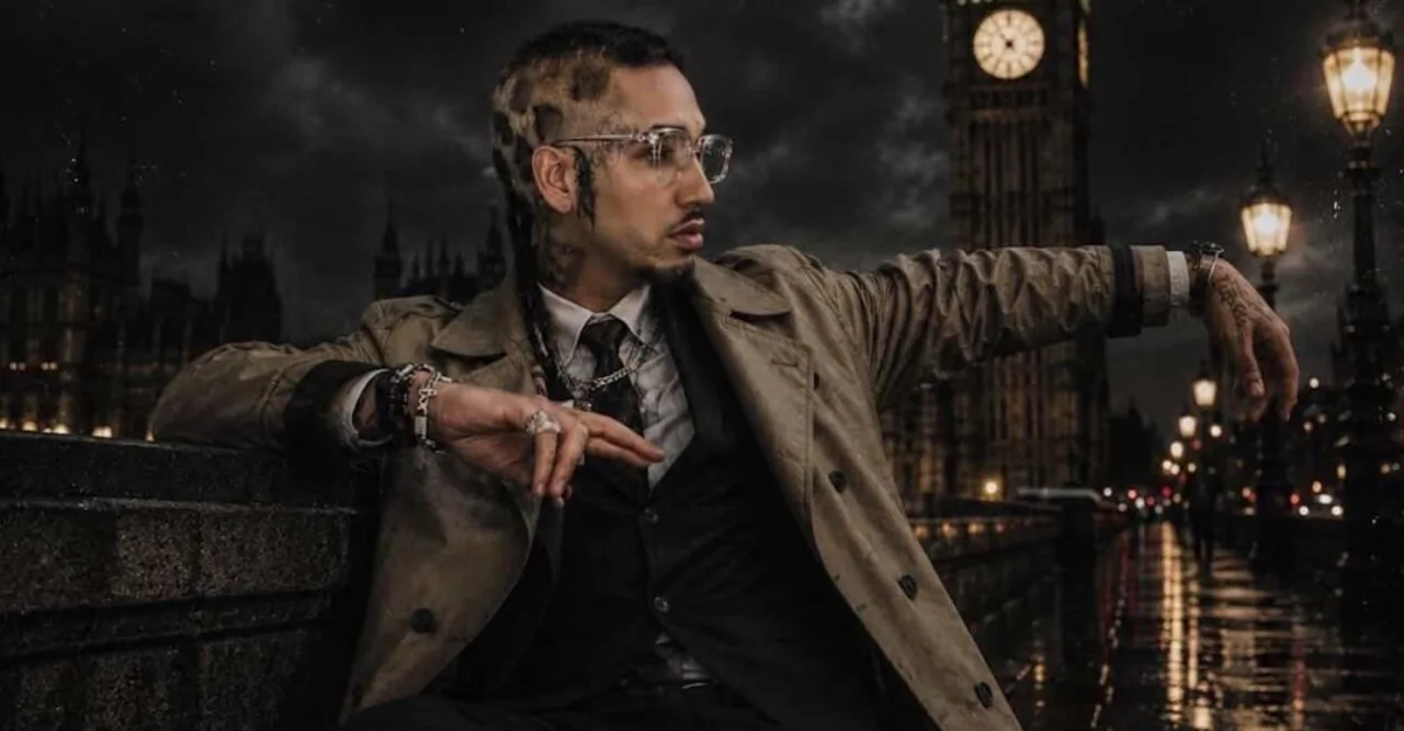 Um rapper em pose de alongamento, usando headphones, ao lado de um laptop aberto mostrando ondas sonoras e uma barra de proteína