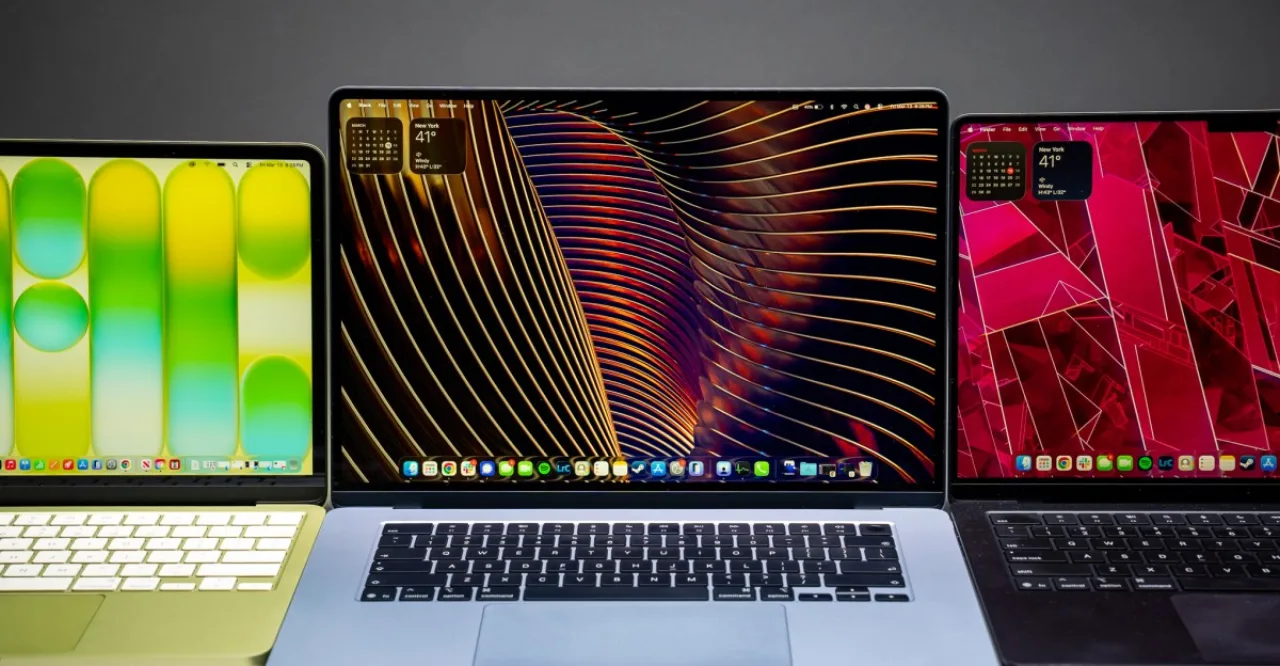 Homem concentrado no MacBook Air, cercado por halteres, colchonete e garrafa d'água, ambientado em academia