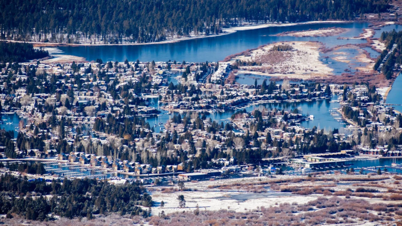 Pessoa praticando ioga em um tapete ao ar livre, com garrafa de água e vista para as montanhas de Lake Tahoe