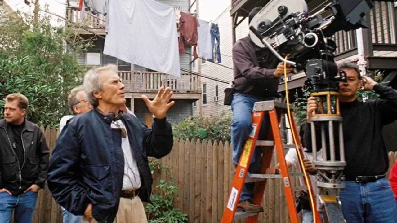 Homem em roupa de treino, segurando controle remoto, assistindo Thunderbolt and Lightfoot na TV