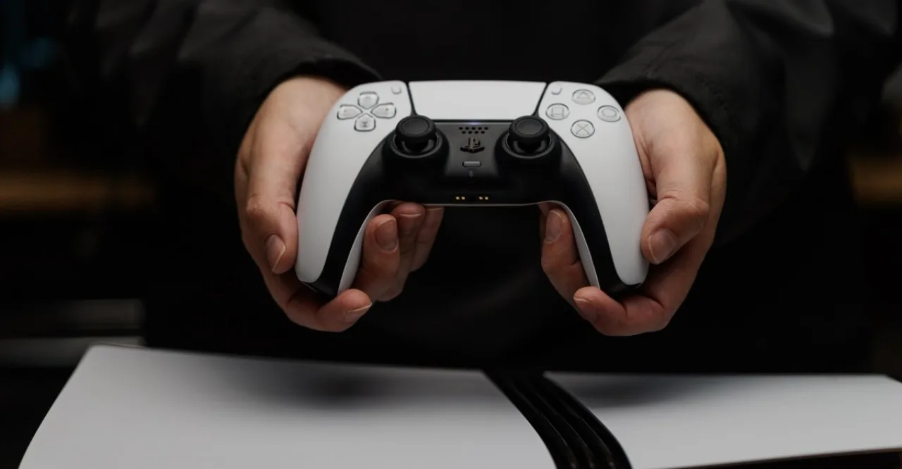 Console PlayStation 5 ao lado de um disco Blu‑ray com o logotipo da Sony ao fundo