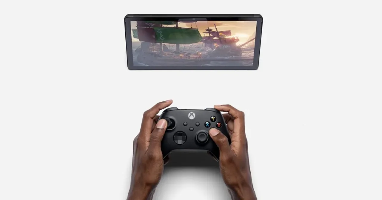 Jovem em roupa de treino usa tablet com Xbox Cloud Gaming, enquanto segura halteres e bebe água