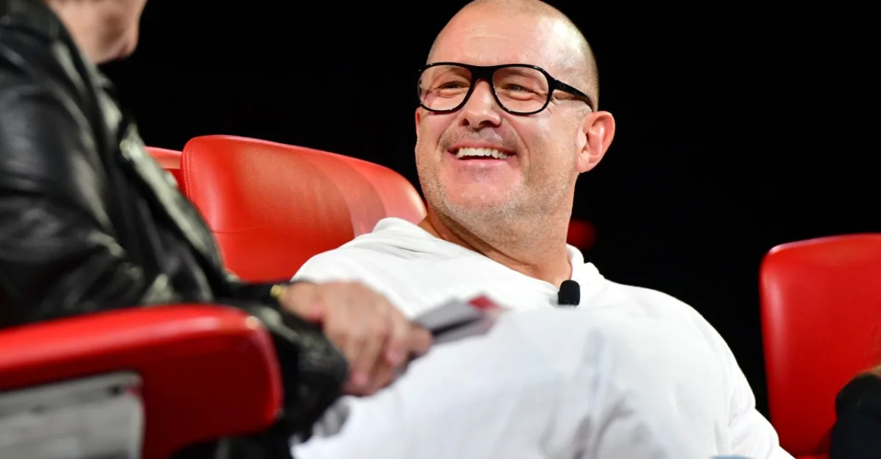 Pessoa vestindo roupa de ginástica usando fones, ao lado de um smart speaker donut sobre tapete de yoga