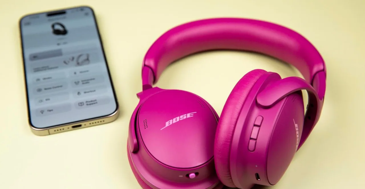 Corredor usando fones Bose, vestindo roupa esportiva, com garrafa d'água e smartwatch na pista ao nascer do sol