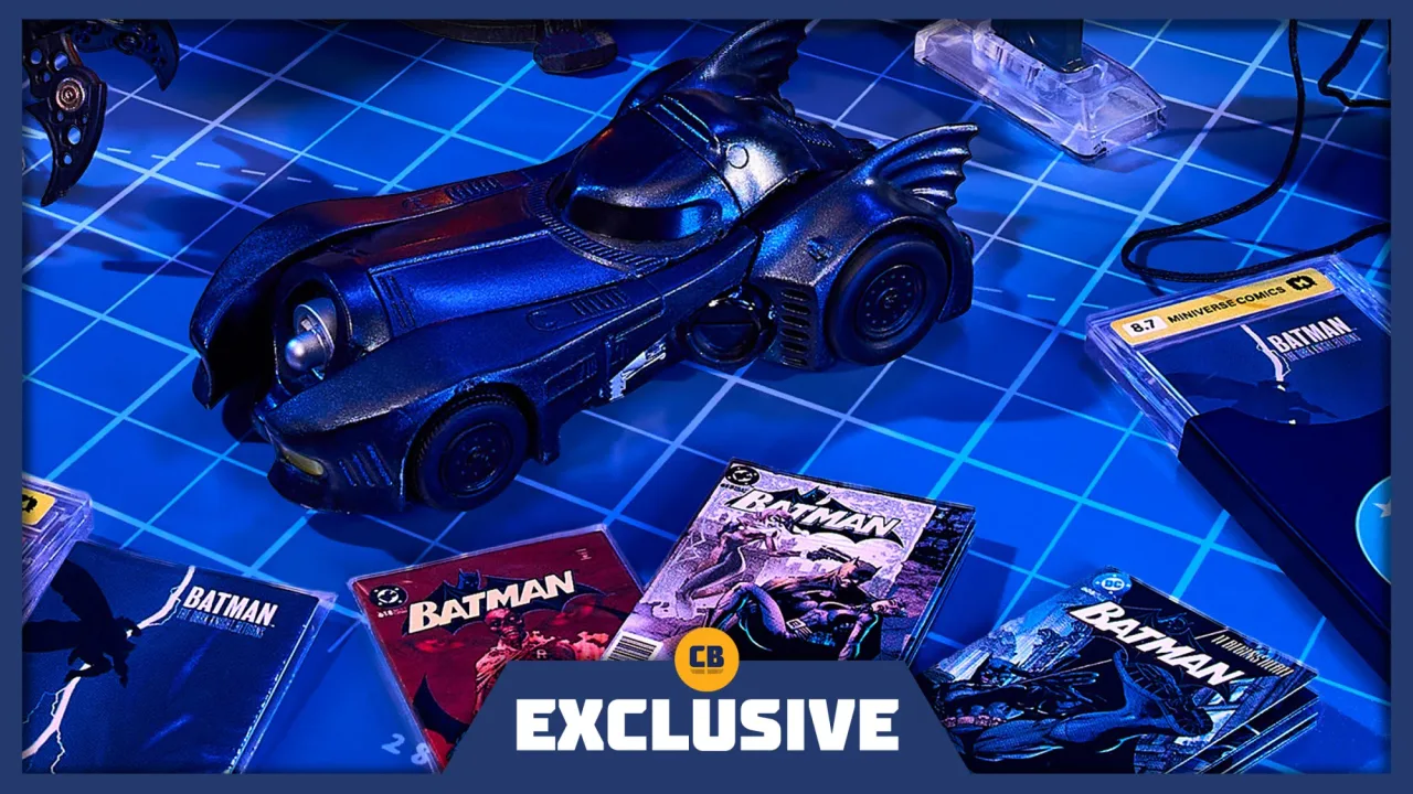 Miniatura do Batmobile ao lado de gadgets como a grappling gun, bat‑signal e uma pilha de mini‑comics da série
