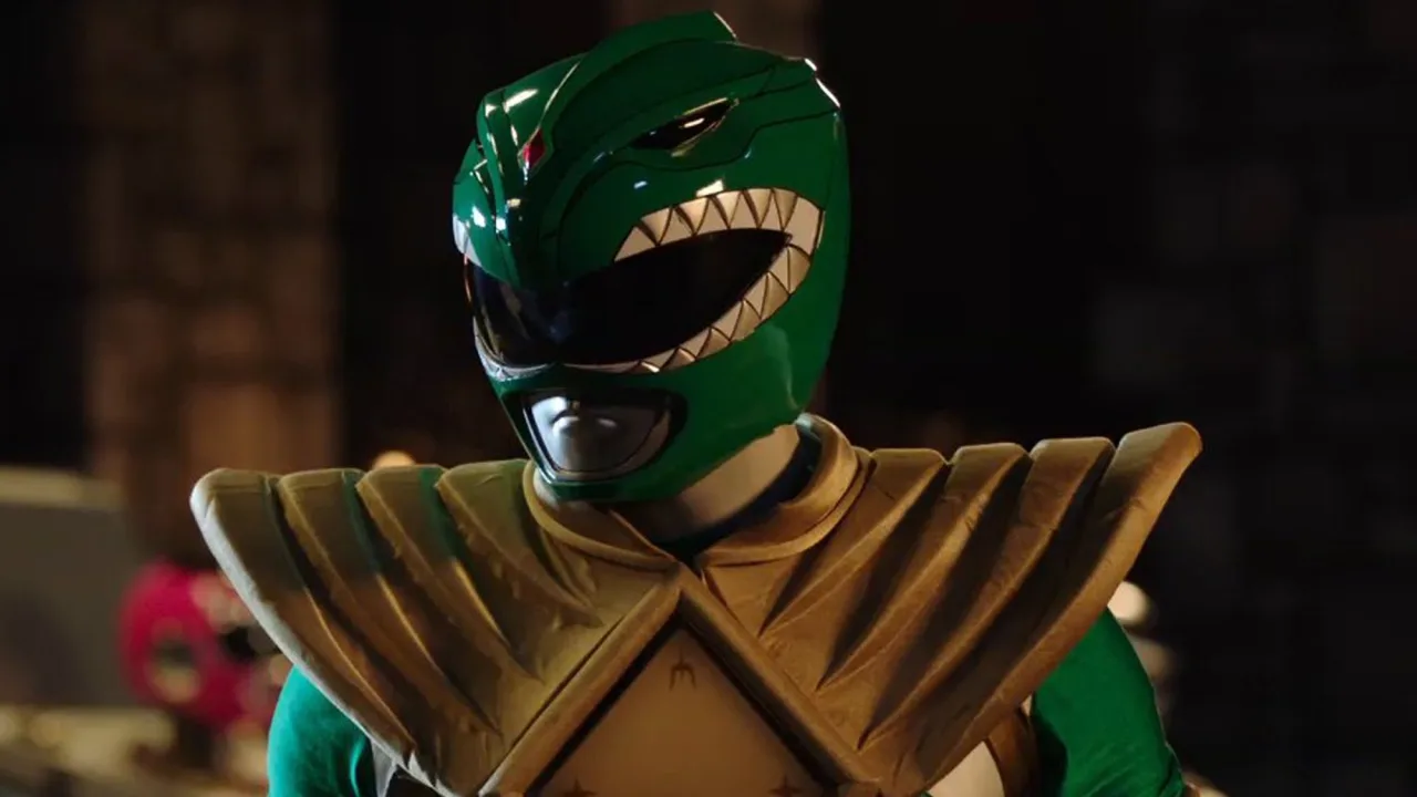 Um atleta musculoso vestindo o novo traje Green Ranger, com luvas pretas, calça verde e detalhes brancos, segurando halteres