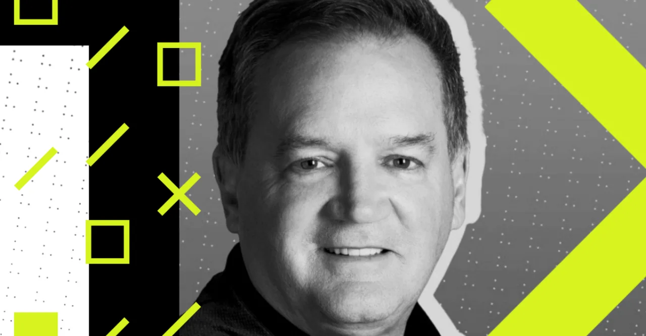 Roger Dahle segurando uma churrasqueira Blackstone com legumes grelhados ao lado