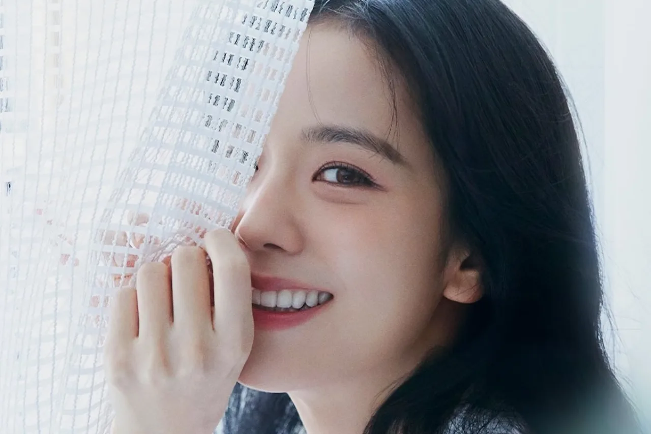 Jisoo vestindo roupa esportiva, segurando halteres, ao lado de um copo de água e uma tigela de frutas vermelhas