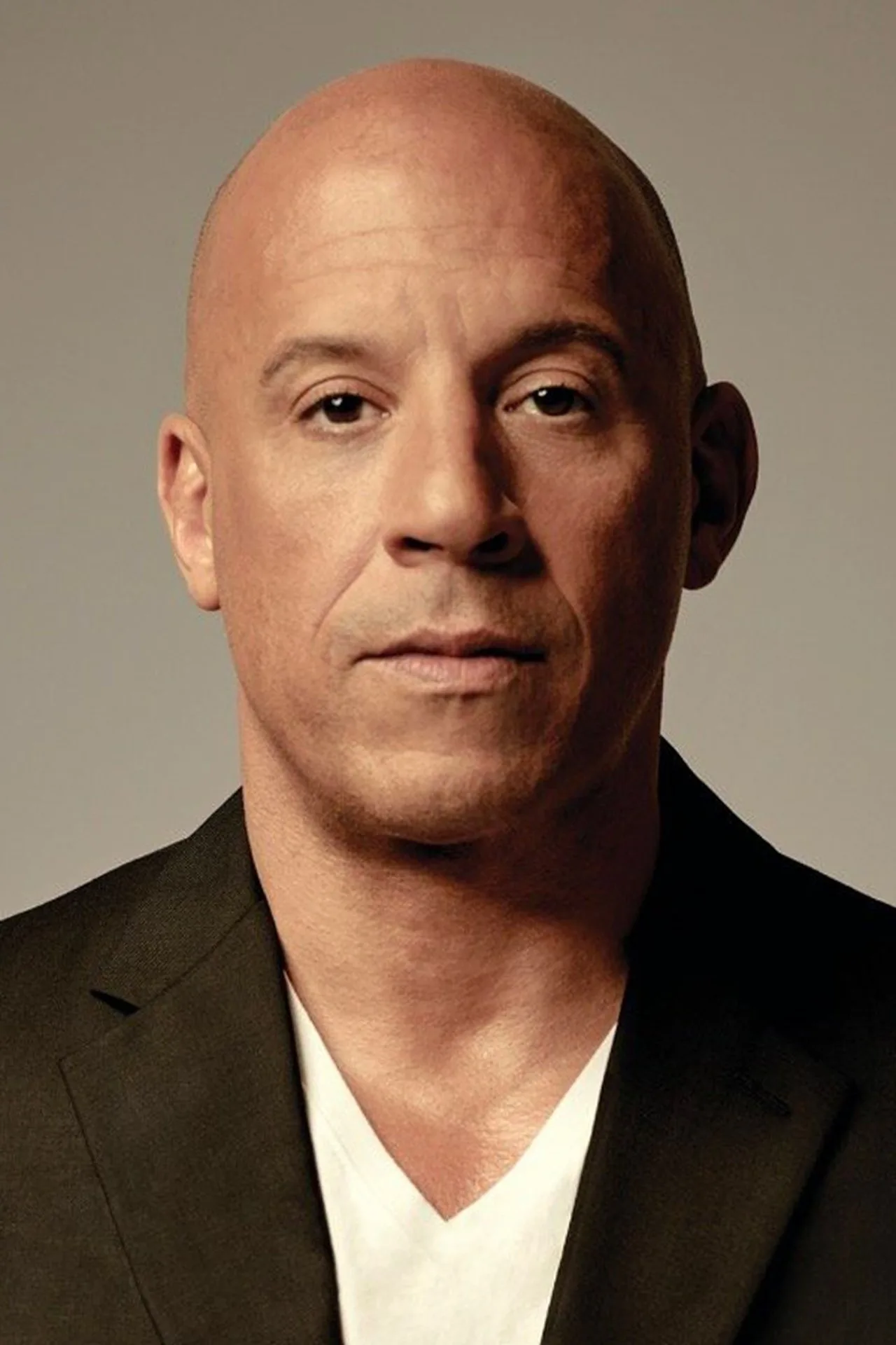Vin Diesel vestindo roupa de treino, segurando halteres ao lado de um Dodge Charger preto e branco