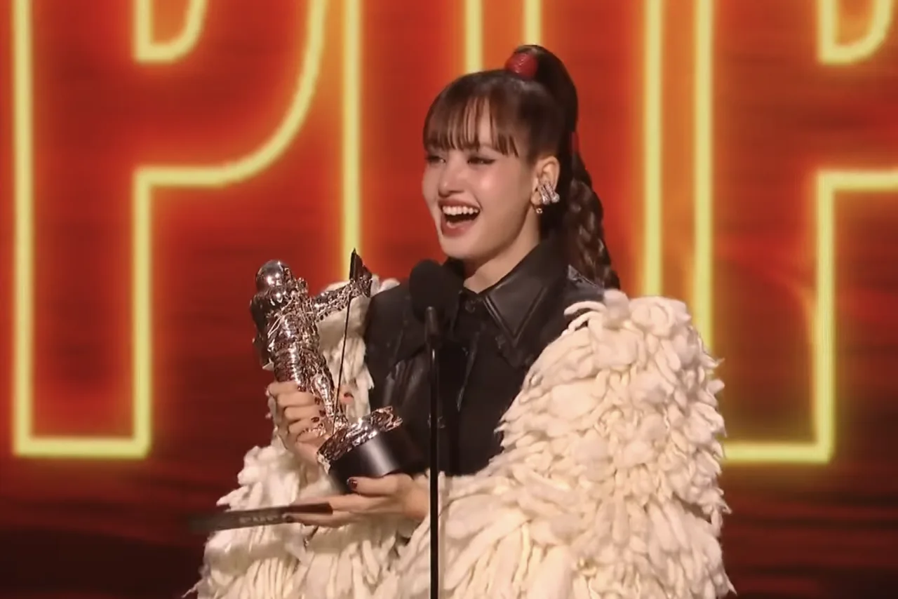 Lisa, vestida de dourado, recebe o troféu Best Pop no palco iluminado do MTV VMA 2026