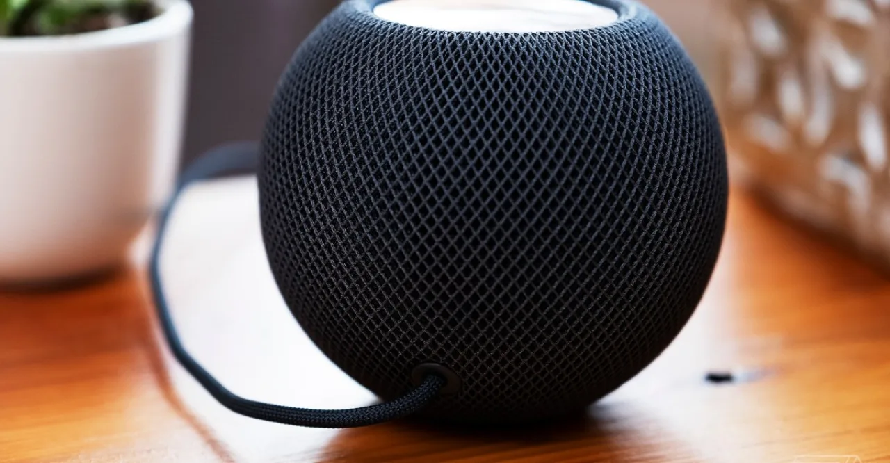 HomePod mini, iPad mini e Apple TV 4K ao lado de trechos de código e logotipo da Apple em fundo escuro