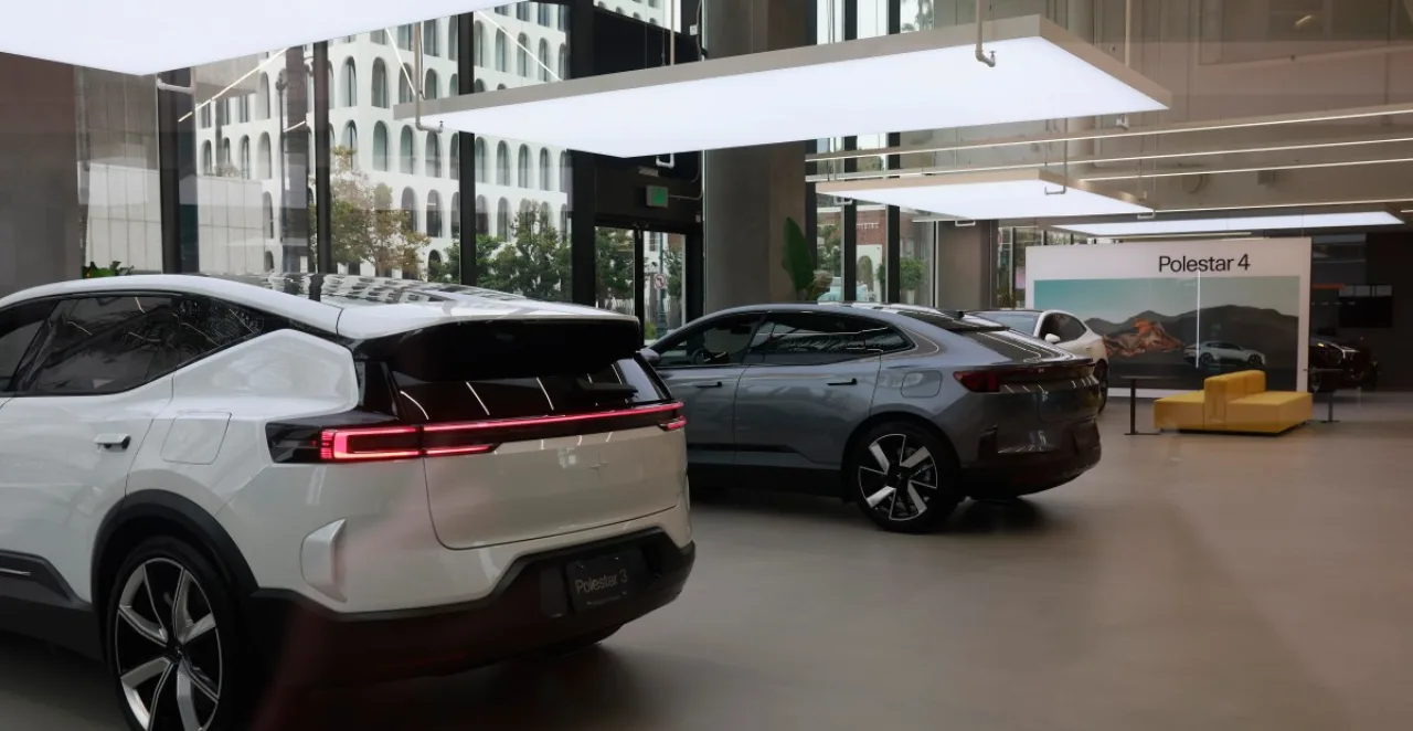 Jovem correndo ao lado de um Polestar 2 estacionado, com carregador conectado e garrafa d’água na mão