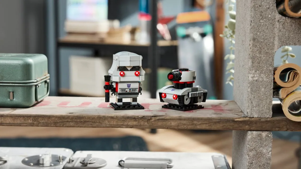 Figura LEGO BrickHeadz do Megatron com blocos cinzas, olhos vermelhos e canhão de fusão sobre base preta minimalista