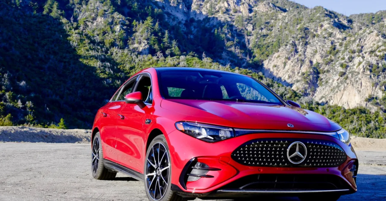 Pessoa moderna carregando um Mercedes-Benz elétrico em um posto de recarga tecnológico com design minimalista