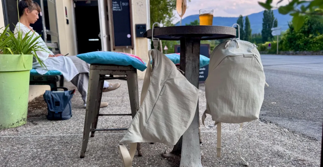 Modelo correndo na rua segurando a bolsa Peak Design City com o gancho BagLev elevado