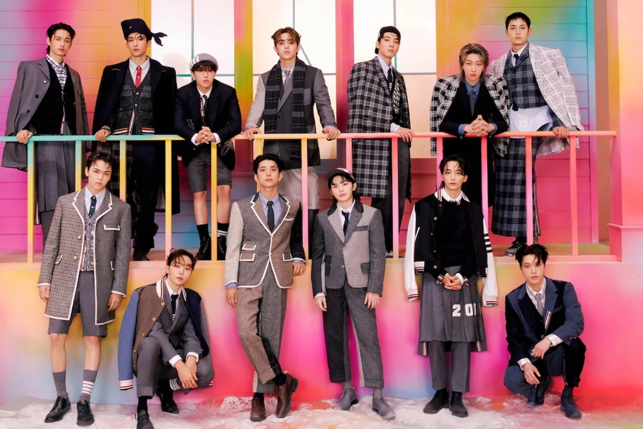 Membros do SEVENTEEN posam em frente ao logo da PLEDIS, ao lado de um martelo de juiz e documentos legais