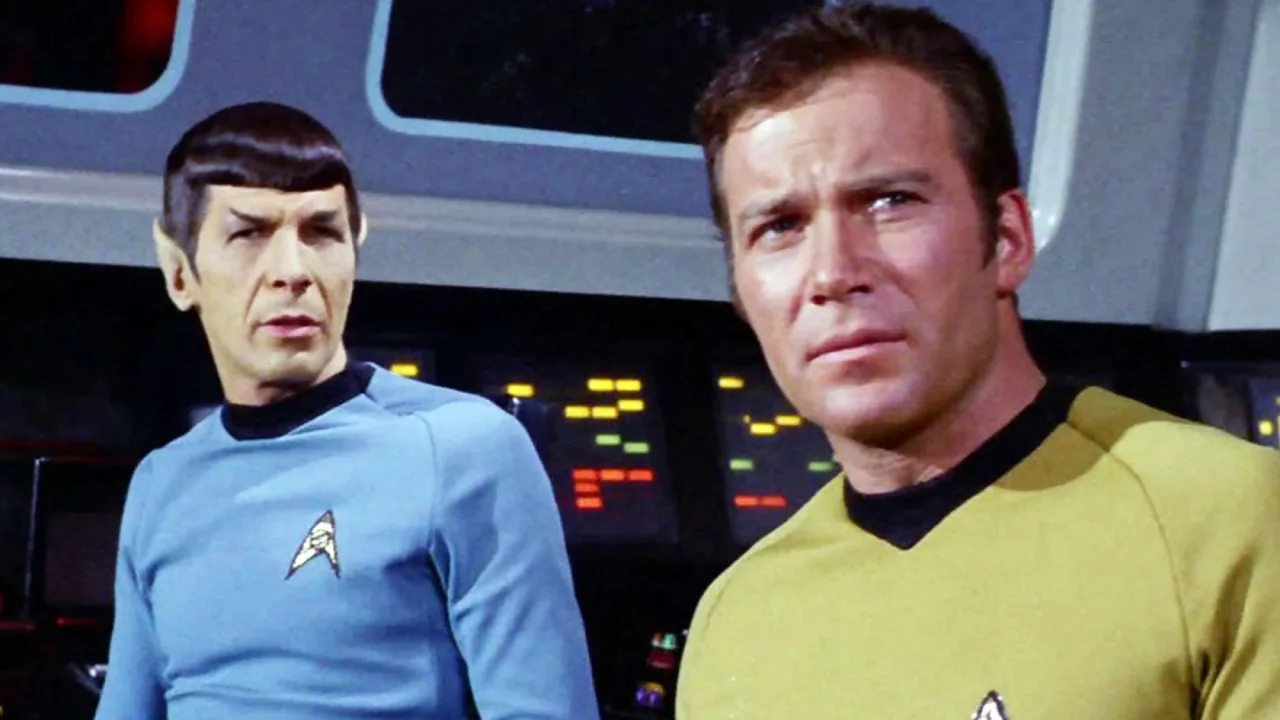 Homem em roupa de ginástica levanta halteres que lembram phasers da série original, ao fundo painel de estrelas