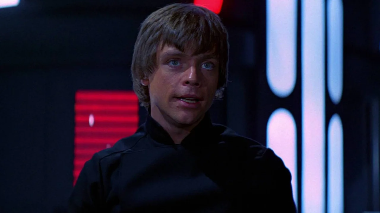 Homem faz agachamento segurando a figura de Luke Skywalker no tapete de yoga, ao lado de halteres e garrafa d'água