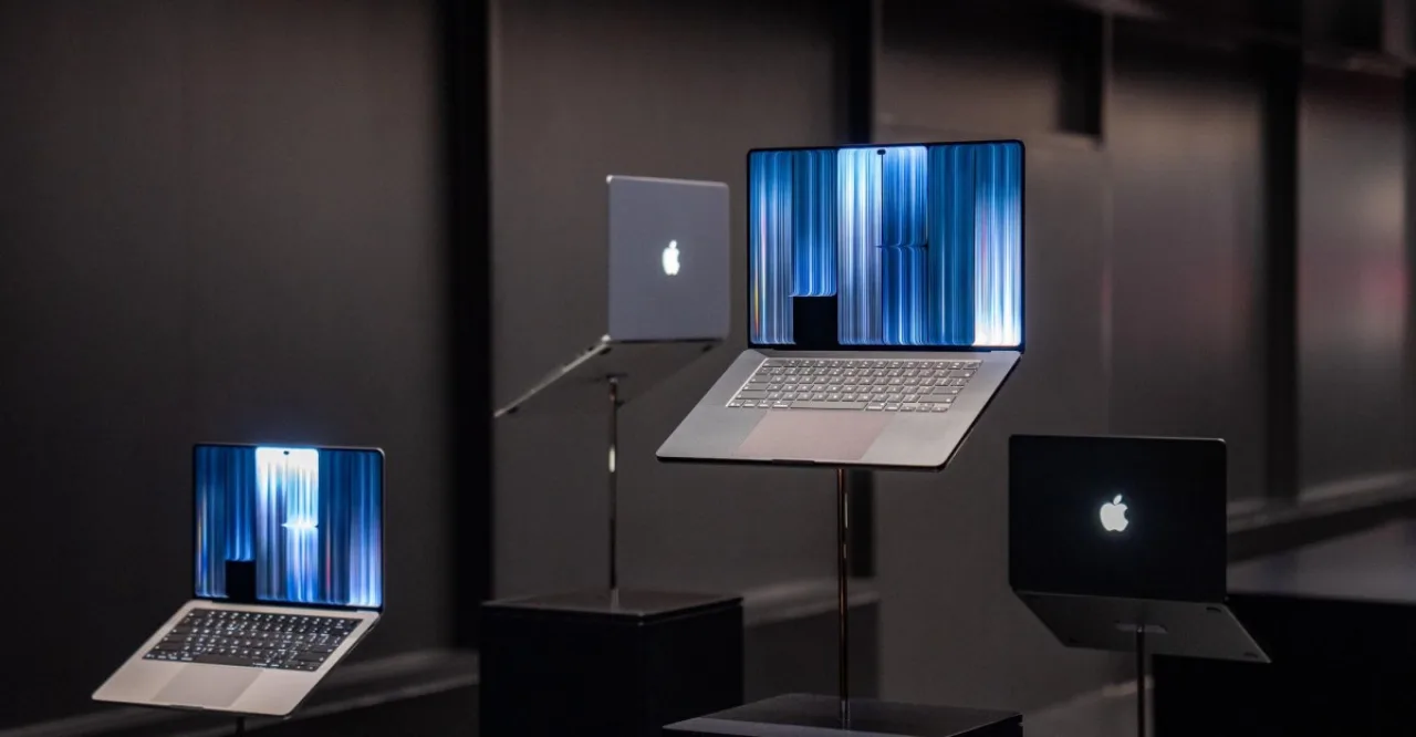 MacBook Pro aberto com tela touch ao lado de logotipo Best Buy e gift card de US$ 100