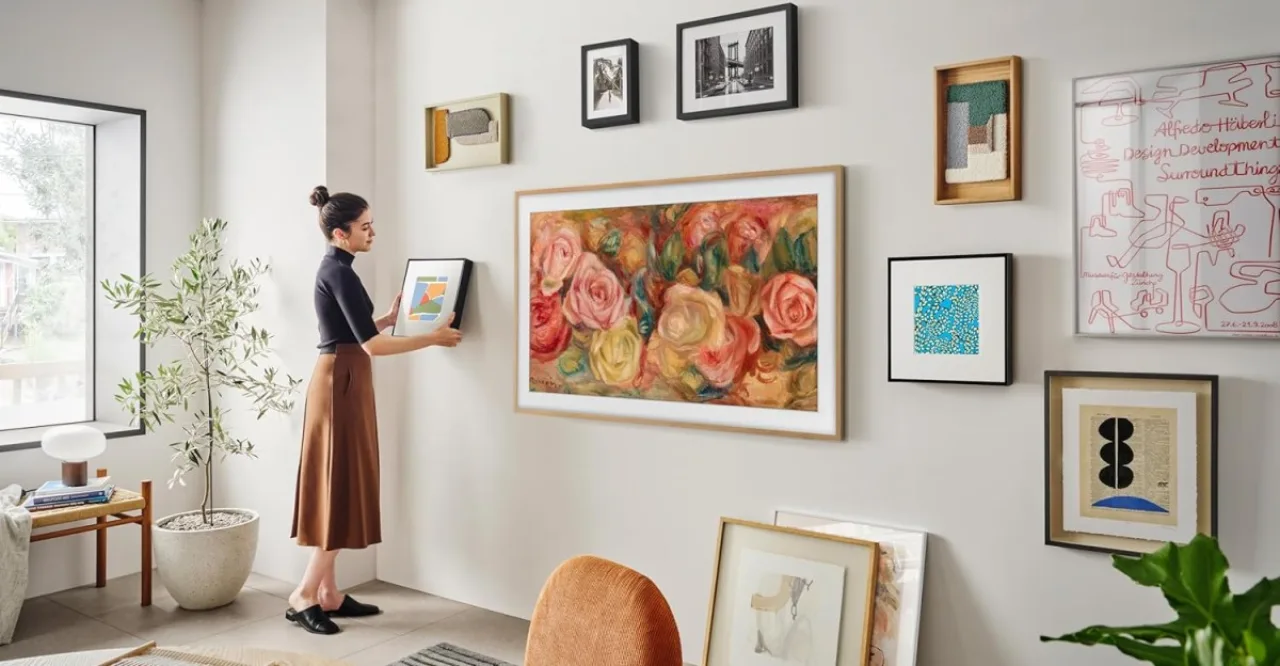 Sala moderna com TV estilo quadro exibindo arte na parede acima de um sofá elegante e decoração minimalista