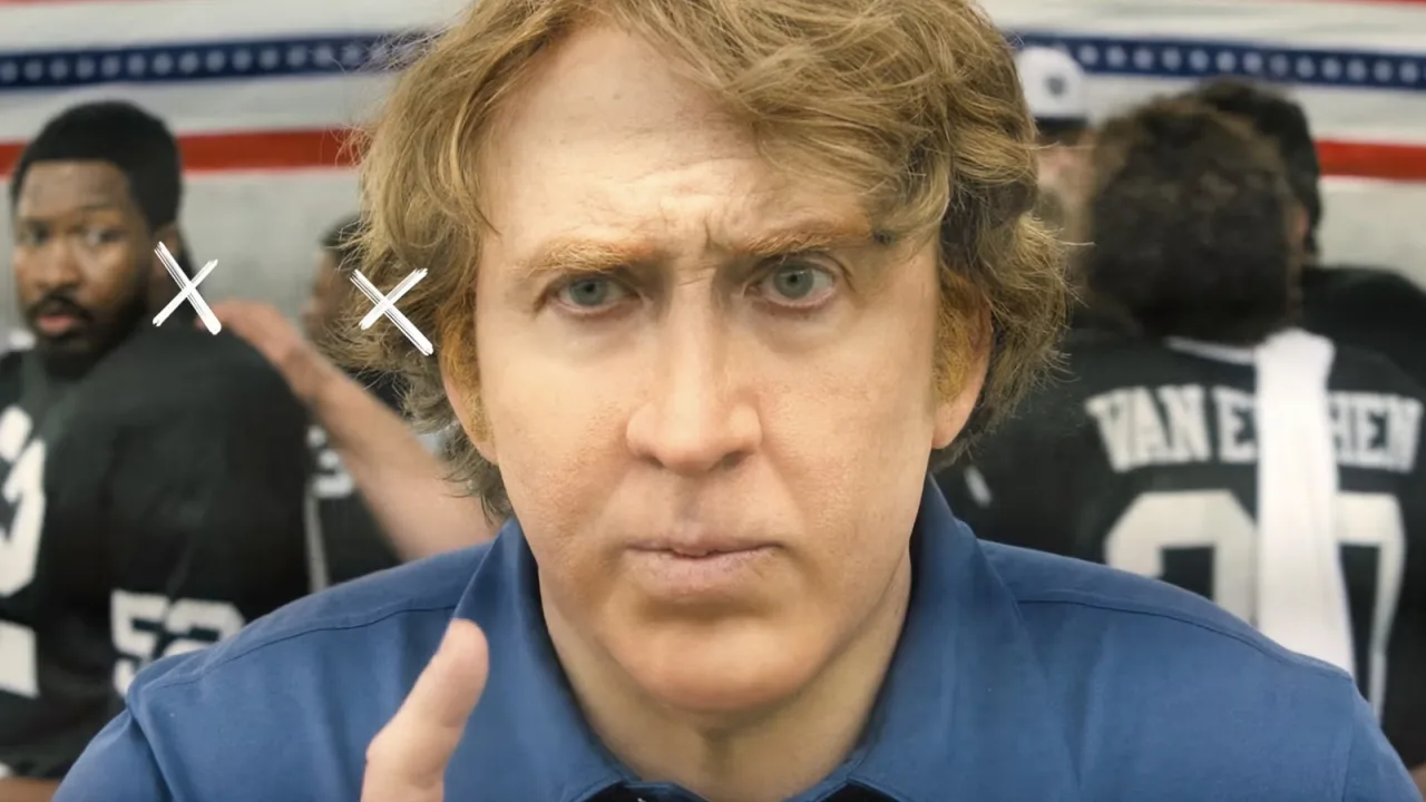 Nicolas Cage, vestido de técnico, segura um futebol ao fundo de um estádio enquanto o logo de Madden brilha