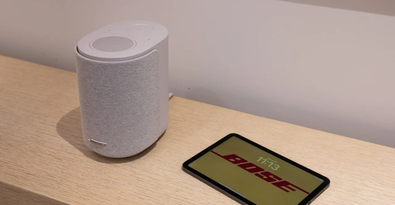 Pessoa praticando ioga em uma sala minimalista com caixas de som Bose Lifestyle Ultra posicionadas no ambiente