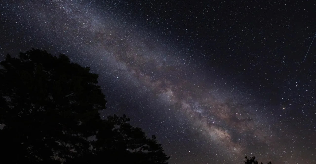 Astronauta em traje segurando halteres ao lado de um foguete em lançamento, simbolizando força e pesquisa espacial