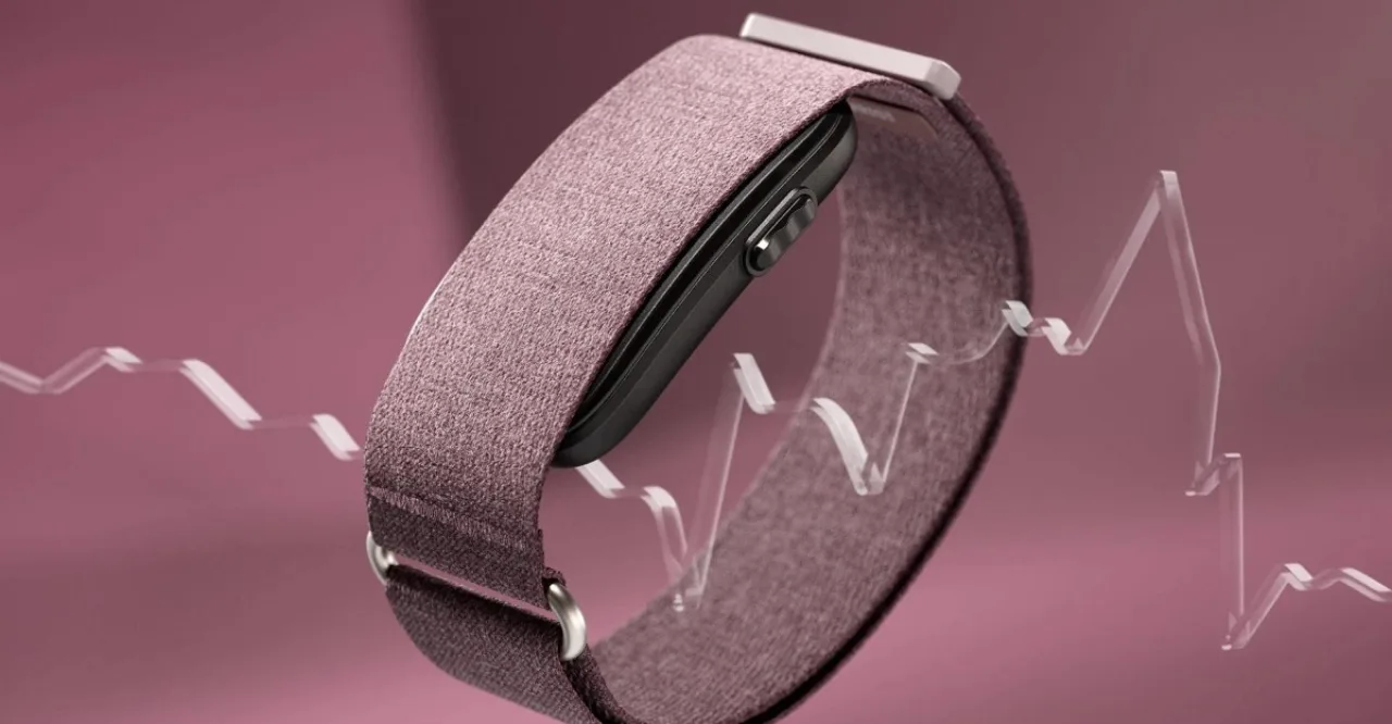 Garmin Cirqa, Whoop 5.0 e Fitbit Air alinhados sobre um tapete de yoga, ao lado de um copo de água e um tênis de corrida