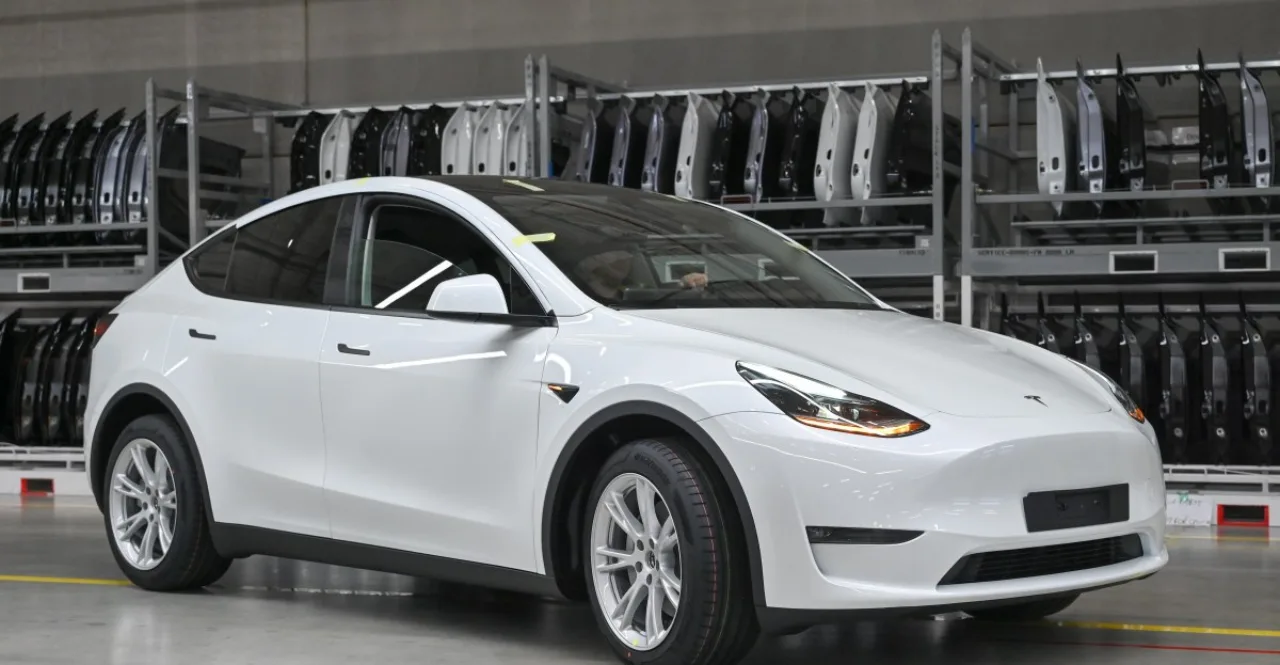 Suspensão de um Tesla Model 3 destacada, com a roda dianteira levantada e componentes metálicos expostos