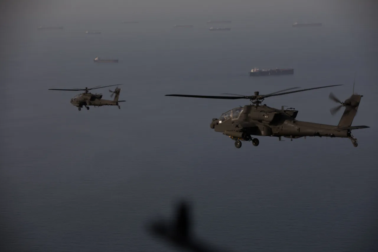 Helicóptero AH‑64 Apache em chamas sobre o Estreito de Hormuz, com fumaça negra e destroços espalhados na água
