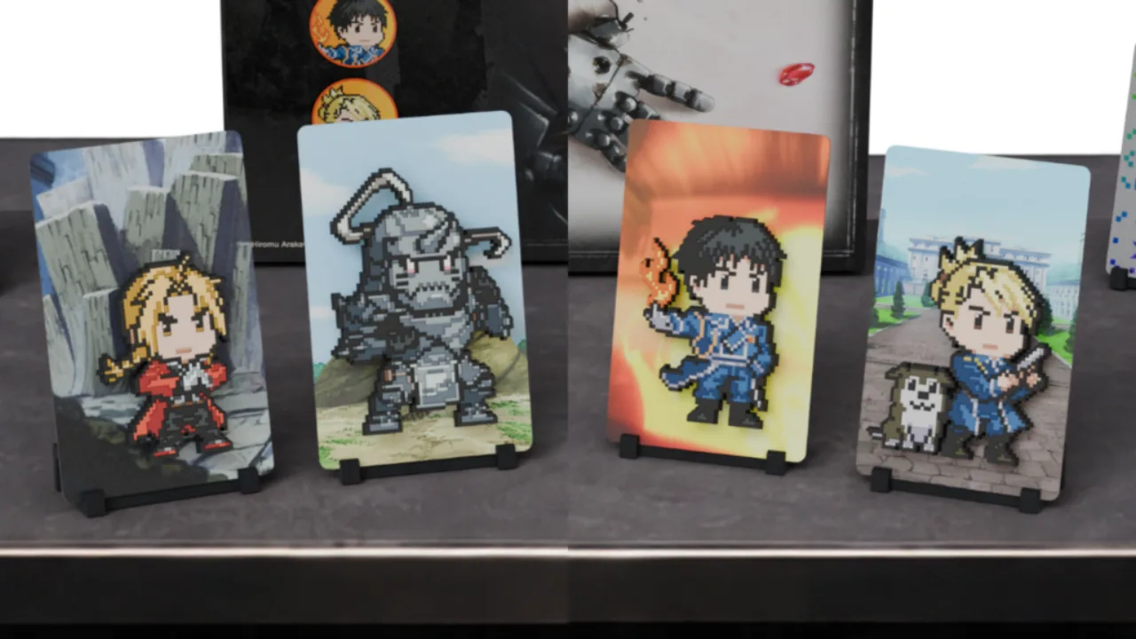 Caixa premium aberta exibe figuras pixel-art de Edward, Alphonse, Roy e Riza sobre fundo neutro