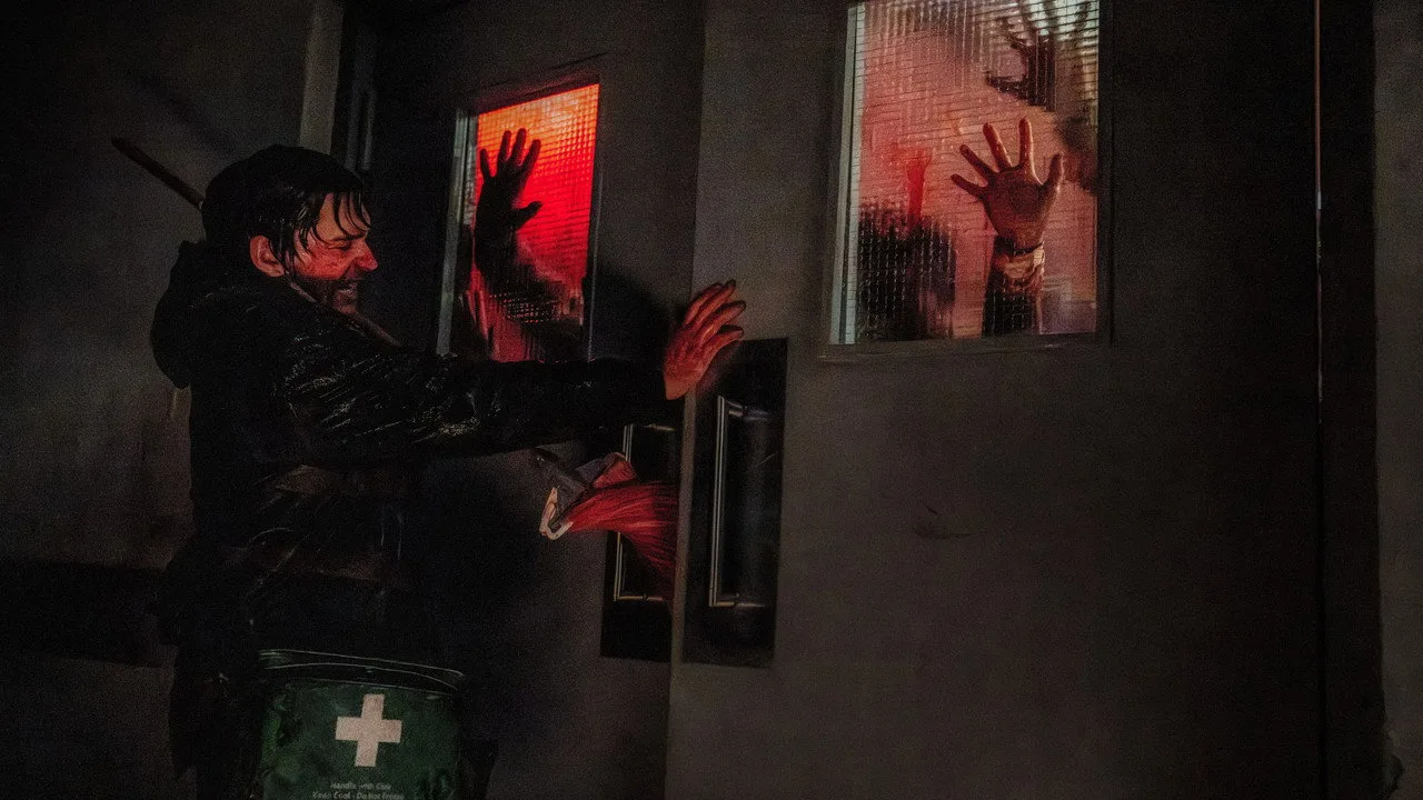 Jovem malhando com barra, camiseta de Resident Evil, enquanto assiste ao trailer em tela ao fundo