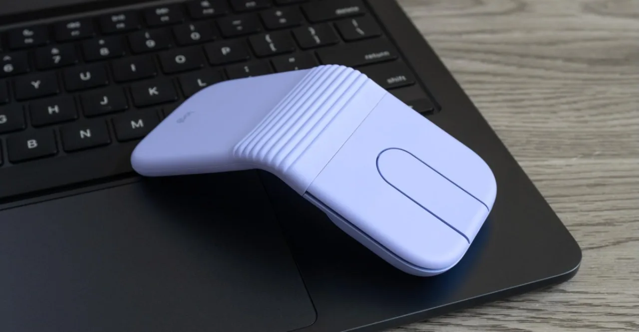 Pessoa em traje esportivo, usando o mouse dobrável Logitech Mobi Fold sobre um laptop, ao lado de garrafa d'água e tênis