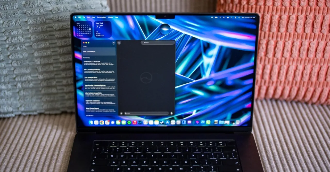 Pessoa praticando yoga em casa, com laptop aberto mostrando a tela do macOS 27 e a Siri AI ativada