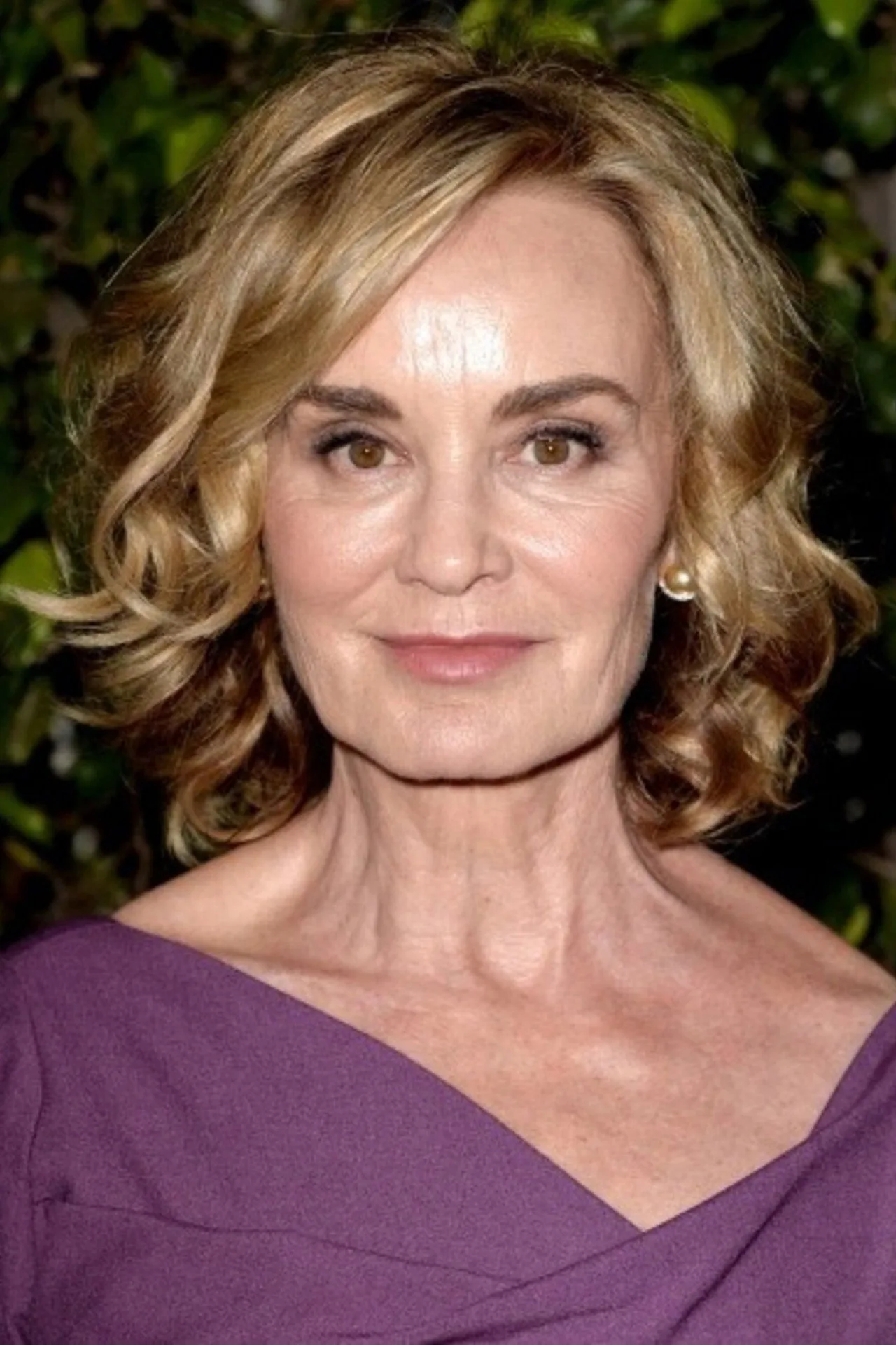 Mulher levantando halteres enquanto assiste a cena de Jessica Lange em AHS na TV